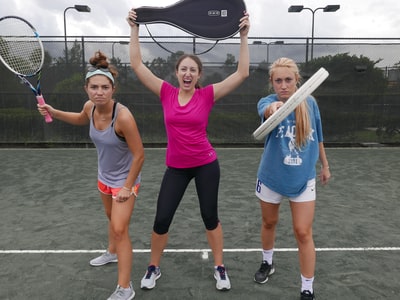 三个女人拿着网球拍
